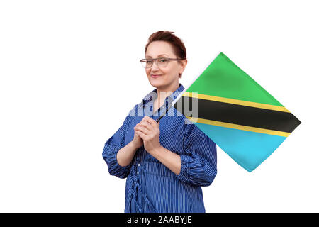 Tanzania flag. Woman holding Tanzanian flag. Nice portrait of middle aged lady 40 50 years old holding a large flag isolated on white background. Stock Photo