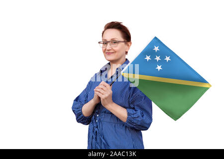 Solomon Islands flag. Woman holding flag. Nice portrait of middle aged lady 40 50 years old holding a large flag isolated on white background. Stock Photo