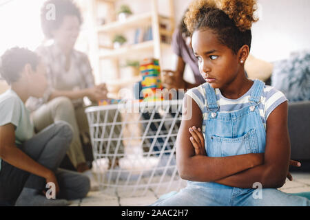 Little rebelious girl has conflict with family. Family problems. Social misbehaviour. Stock Photo