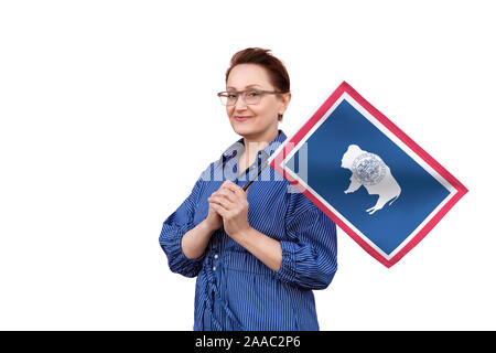 Wyoming flag. Woman holding Wyoming flag. Nice portrait of middle aged lady 40 50 years old holding a large flag isolated on white background. Stock Photo