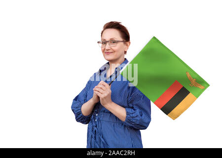 Zambia flag. Woman holding Zambia flag. Nice portrait of middle aged lady 40 50 years old holding a large flag isolated on white background. Stock Photo