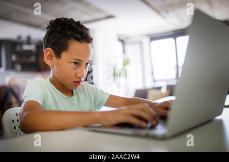 Boy spending time with notebook and modern technology Stock Photo