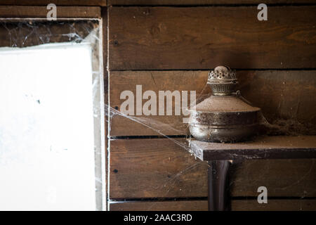 An old kerosene lamp in a cobweb in a country house Stock Photo