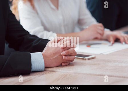 Close-up of male and female hands on table. Business people discussing marketing report Stock Photo