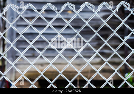 Ice on a fence made of metal mesh. Icy rain in the winter. Atmospheric phenomena of nature. Close up. Stock Photo