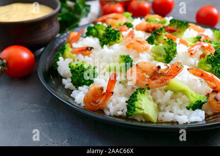 Rice with broccoli, shrimps and cream cheese sauce. Healthy and tasty food. Proper nutrition. Sports diet. Stock Photo