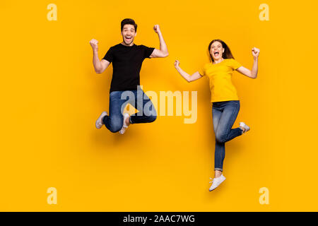 Full body photo of crazy guy lady couple jumping high celebrating first win place competition triumphing wear casual jeans black t-shirts isolated Stock Photo