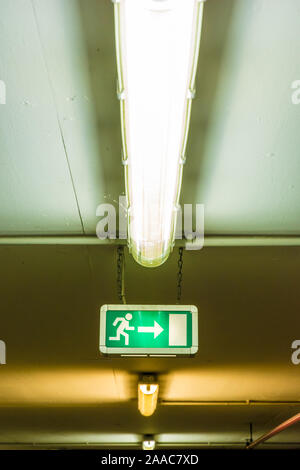 Illuminated sign on the ceiling shows the emergency exit Stock Photo