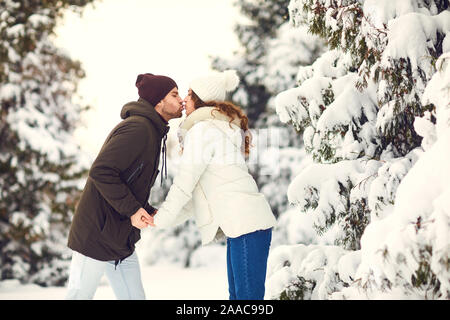 Man and woman kissing in snowy forest Stock Photo