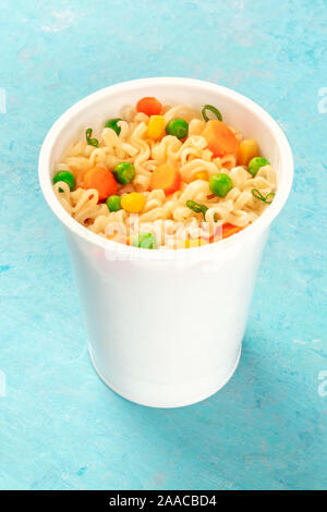 Ramen cup, instant soba noodles in a plastic cup with vegetables close-up Stock Photo