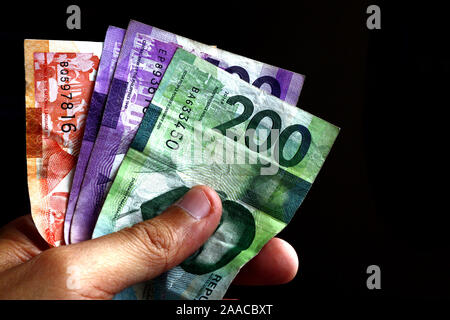 Photo of hand holding Philippine peso bills Stock Photo