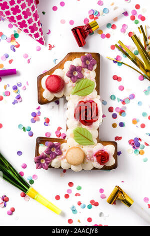 Number one cake decorated with flowers, macarons and confetti isolated on white background Stock Photo
