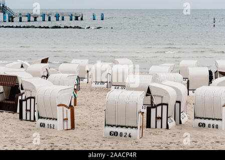 Hooded beach chairs in Baltic sea beach a cloudy day of Summer. Sellin, Rugen Island. Germany Stock Photo
