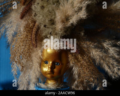 Doll Head, gold, arrangement with grasses Stock Photo