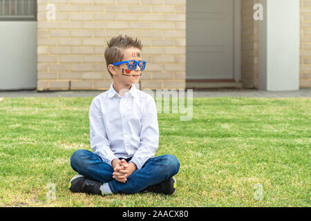 Portrait of Australian boy with flag tattoo on his chick and sunglasses.  Australia Day theme Stock Photo