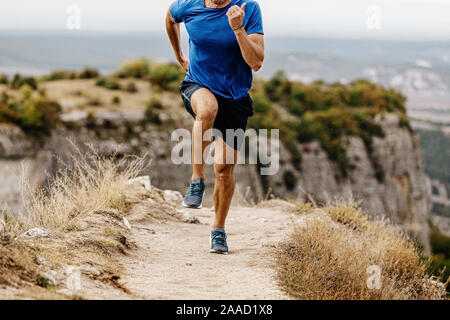 run mountain trail on edge of cliff male runner Stock Photo