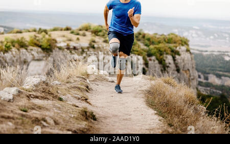 male runner running in knee pads on mountain trail Stock Photo