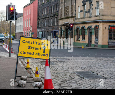 Leith, Edinburgh, Scotland, United Kingdom. 21st Nov, 2019. Trams to Newhaven work starts: Constitution Street is closed to traffic for the next 2-3 years to build the extension for Edinburgh's tram line from to Newhaven, with 8 more stops over 2.91 miles. The work is being undertaken by SFN (Sacyr Farrans Neopul) and MUS (Morrison Utility Services). A road closed sign and barrier of traffic cones Stock Photo