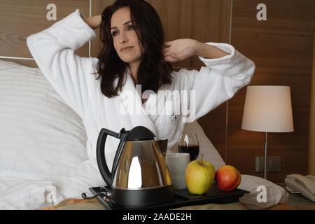 Junge muede Frau macht Fruehstueck im Bett Stock Photo