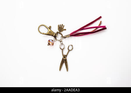 Beautiful keychain jewelry made with antique gold, crystal glass and leather straps isolated on white background. Stock Photo