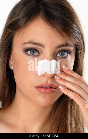 Junge Frau mit Nasenpflaster