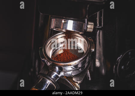 Coffee grinder grinding freshly roasted beans into a powder Stock Photo