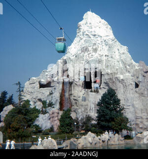 Vintage September 1972 photograph, the Skyliner aerial tram passing through Matterhorn Bobsleds mountain at Disneyland theme park in Anaheim, California. SOURCE: ORIGINAL 35mm TRANSPARENCY Stock Photo