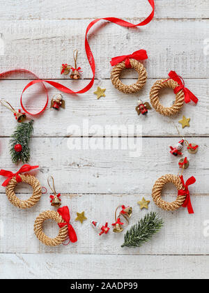 Classical Christmas wreath with red details with a copy space in the middle on a white wooden background Stock Photo