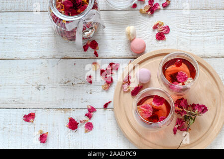 Two cups of dried rose petals tea on a white wooden table. Morning tea for two Stock Photo