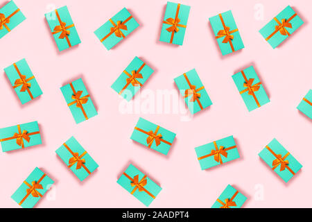 Pattern with orange bow on a mint boxes located on pink background. Stock Photo