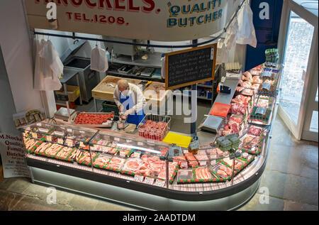 Butcher making meat burgers at his shop stall in the indoor market viewed from above Scarborough North Yorkshire England UK United Kingdom Britain Stock Photo