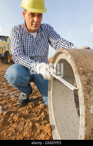 Bauarbeiter arbeitet mit Rohr Stock Photo