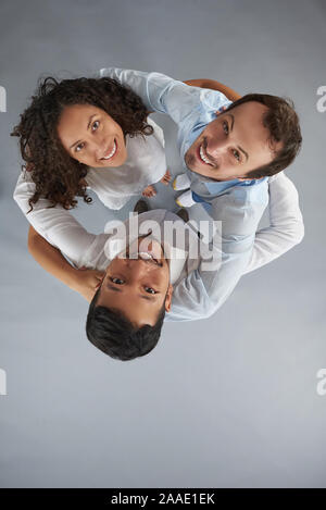 Group of young smiling people looking up  above top view in studio background Stock Photo