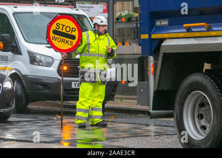 Lollipop Stop And Go Traffic Sign; Traffic Control Workman holding traffic with handheld Stop sign, UK Stock Photo