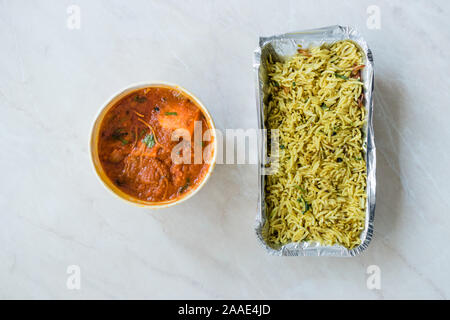 Take Away Indian Food Paneer Butter Tikka Masala / Cheese Cottage Curry and Jeera Zira Rice Basmati Pilaf or Pilav in Plastic Box Package / Container. Stock Photo