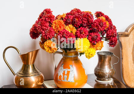 Still-life with sprays of home-grown spray Chrysanthemum flowers displayed in a Grecian vase indoors Stock Photo
