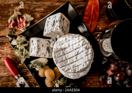 Fresh grapes and wine and tasty cheese on wooden table top. Stock Photo