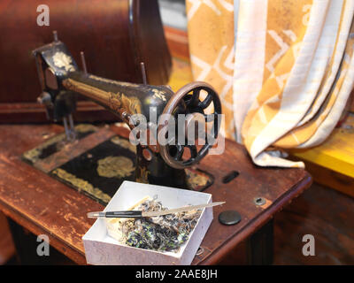Vintage sewing machine and box with threads, indoor close-up Stock Photo