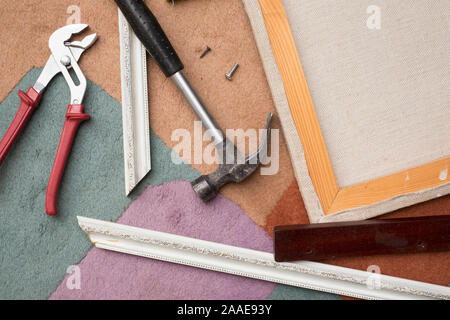 Hand tools around an artist canvas and wooden frame parts Stock Photo