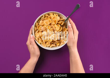 Food, healthy eating, people and diet concept - close up of woman eating muesli for breakfast over purple background Stock Photo