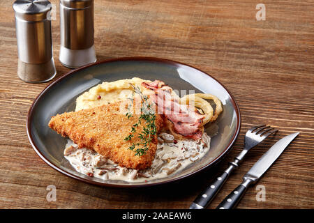 Meat with garnish , chicken cutlets in breadcrumbs , boiled mashed potatoes with herbs , garlic and spices on a wooden background Stock Photo