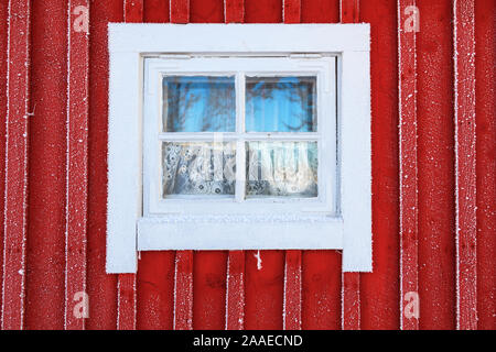 Window on the red cottage with frost Stock Photo