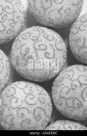 Christmas background. White Christmas balls with silver pattern close-up. Beautiful Christmas Wallpaper. Stock Photo