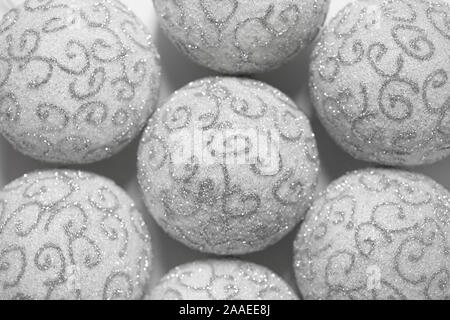 Christmas background. White Christmas balls with silver pattern close-up. Beautiful Christmas Wallpaper. Stock Photo