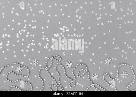 Christmas border with silver snowflakes, stars and garland on grey background. Happy New Year. Winter concept. Top view, flat lay. Greeting card. Stock Photo
