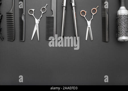 Flat lay composition with Hairdresser tools: scissors, combs, hair iron on black background with copy space for text. Frame. Hairdresser service Stock Photo