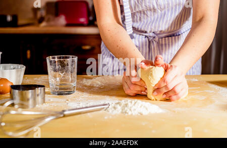 Woman's hands knead dough on a table, for the holiday Stock Photo
