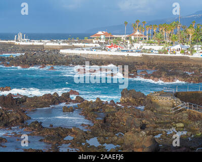 View over the volcanic rocky shore at Puerto de la Cruz, Tenerife, Canary Islands, to Lago Martianez lido Stock Photo