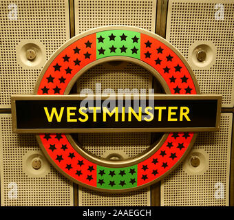 Westminster unusual underground roundel logo, written in yellow on a black background with a yellow and red circle. Close up sign on beige background. Stock Photo