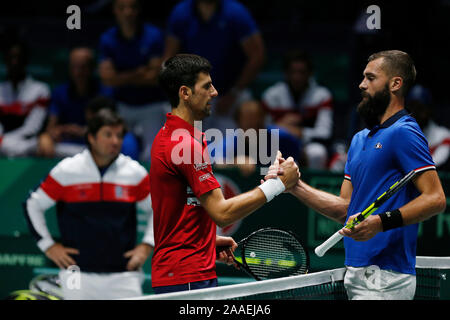 Novak Djokovic of Serbia and Benoit Paire of France shake hands during Day 4 of the 2019 Davis Cup at La Caja Magica. Stock Photo